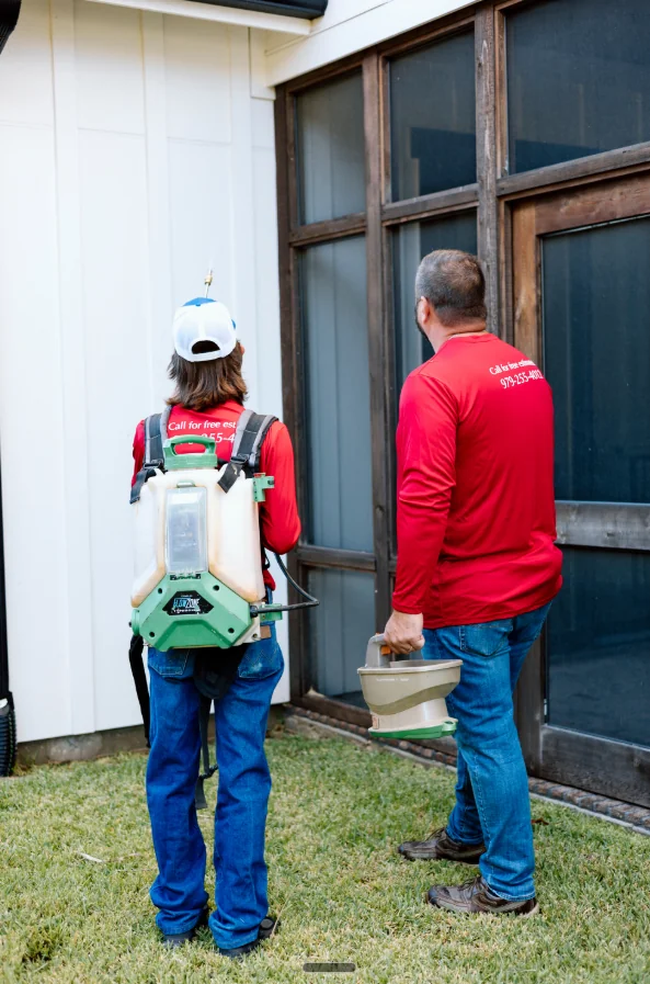 Two D&D Pest Services team members at a residential home, ready to treat.